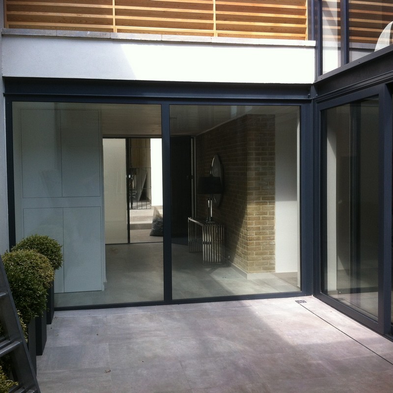 Floor-to-ceiling sliding doors opening to courtyard in Isleworth
